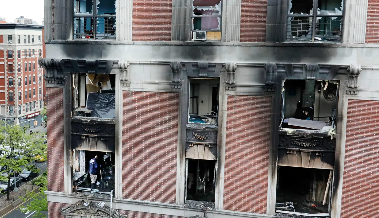 Petugas pemadam kebakaran memeriksa apartemen yang terbakar di kawasan Harlem, New York, Amerika Serikat, Rabu (8/5/2019). Kebakaran tersebut menewaskan enam orang termasuk di antaranya empat anak-anak. (AP Photo/Richard Drew)