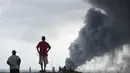 Warga melihat asap pekat yang ditimbulkan dari lokasi ledakan di kompleks petrokimia perusahaan minyak nasional Pemex di Meksiko Timur, Rabu (20/4). Sedikitnya tiga orang tewas dan 45 lainnya luka-luka akibat ledakan. (REUTERS/Angel Hernandez)