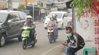 Seorang penagih utang tengah memperhatikan nomor polisi sepeda motor (Liputan6.com/Balgoraszky Marbun)