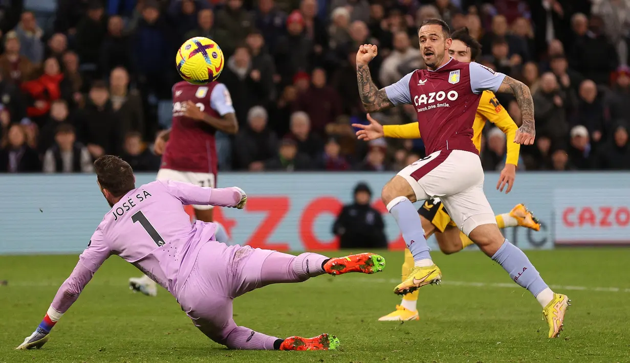 Striker Aston Villa, Danny Ings (kanan) mencetak gol ke gawang Wolverhampton Wanderers yang dikawal Jose Sa pada laga Liga Inggris 2022/2023 di Villa Park, Birmingham (4/1/2023). Danny Ings yang pada tengah musim 2022/2023 hijrah ke West Ham United, mampu mencetak 6 gol dari total 18 laga di paruh pertama Liga Inggris 2022/2023 bersama Aston Villa. (AFP/Adrian Dennis)
