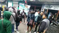 Anggota Anarko Sindikalis menggunakan penutup wajah dan hoodie berwarna hitam ikut dalam aksi May Day di Surabaya. (Liputan6.com/Dian Kurniawan)