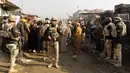 Petugas keamanan Irak berjaga dengan senjata lengkap disekitar lokasi ledakan di pasar sayur Jumila, Baghdad, Irak (8/1). Akibat ledakan bom tersebut, belasan orang dilaporkan tewas dan banyak lainnya menderita luka-luka. (AFP/Sabar Arar)