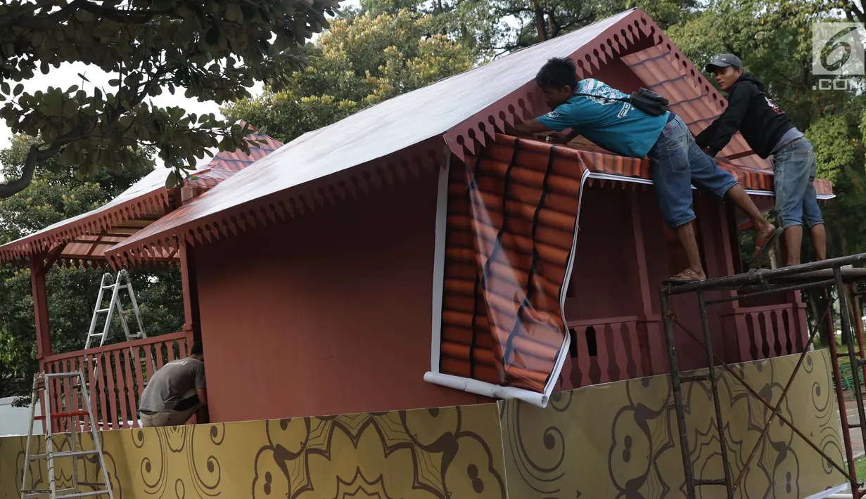 Pekerja menyelesaikan pembuatan miniatur Rumah Adat Betawi di atas kendaraan hias di kawasan Monas, Jakarta, Jumat (28/6/2019). Kendaraan hias tersebut dipersiapkan untuk mengikuti Jakarnaval 2019 yang merupakan perayaan HUT ke-492 DKI Jakarta, Minggu (30/6). (Liputan6.com/Helmi Fithriansyah)