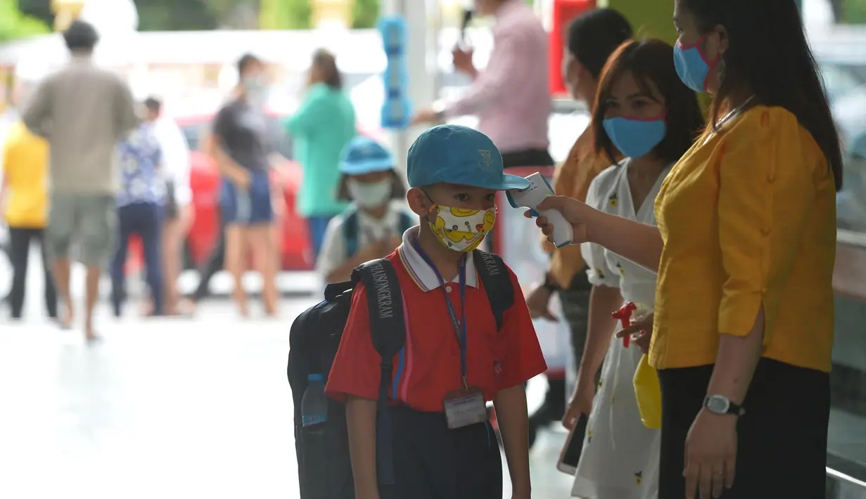 Seorang siswa diukur suhu tubuhnya di pintu masuk sebuah sekolah di Bangkok, Thailand (1/7/2020). Sekolah-sekolah di Thailand telah dibuka kembali pada Rabu (1/7). (Xinhua/Rachen Sageamsak)