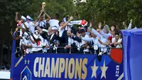 Pemain timnas Prancis, Raphael Varane memegang trofi Piala Dunia 2018 saat pawai dengan bus atap terbuka di sepanjang Champs Elysees, Paris, Senin (16/7). Prancis meraih trofi Piala Dunia kedua usai mengalahkan Kroasia. (Eric Feferberg/Pool via AP)