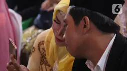 Pasangan peserta nikah massal jelang pelaksanaan itsbat nikah di halaman Balai Kota DKI Jakarta, Selasa (31/12/2019). 633 pasangan, terdiri dari pernikahan baru 143 pasangan dan 490 pasangan itsbat nikah mengikuti acara nikah massal yang digelar Pemprov DKI Jakarta. (Liputan6.com/Helmi Fithriansyah)