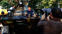 Seorang warga memotret anaknya menaiki Panser Anoa dalam pameran road to campus Alat Utama Sistem Persenjataan (Alutsista) di kawasan Boulevard Universitas Indonesia, Depok, Jawa Barat, Kamis (27/8/2015). (Liputan6.com/Yoppy Renato)