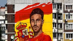Mural begambar bek Spanyol Sergio Ramos terlihat di sebuah bangunan perumahan di Krasnodar, Rusia, Rabu (6/6). Meski dimusuhi karena perannya dalam cedera Mohamed Salah, Ramos tetap memikat hati pecinta bola Krasnador. (Pierre-Philippe MARCOU/AFP)