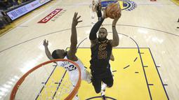 Pemain Cavaliers, LeBron James (kanan) mencoba mencetak poin saat diadang pemain Warriors, Draymond Green pada gim pertama final NBA basketball di Oakland, California, (31/5/2018). Warriors menang 124-114. (Ezra Shaw/Pool Photo via AP)