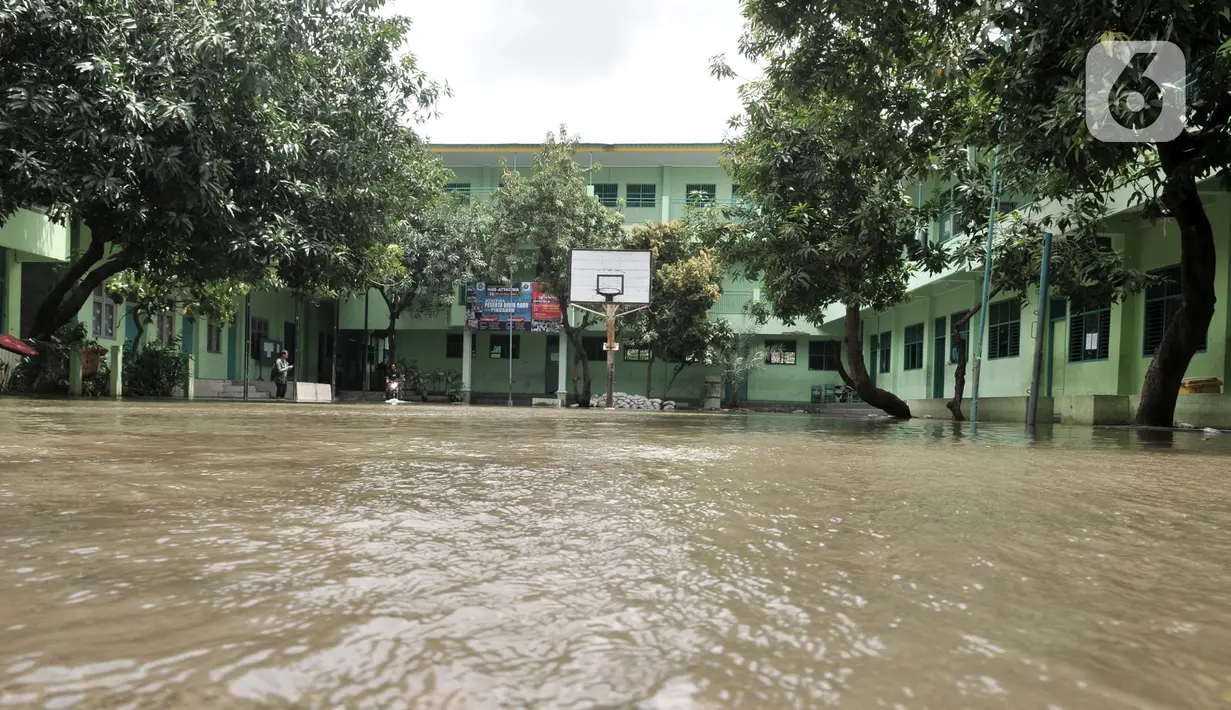 Kondisi banjir yang masih menggenangi gedung Madrasah Tsanawiyah (MTs) Nur Attaqwa, Pegangsaan Dua, Kelapa Gading, Jakarta Utara, Senin (24/2/2020). Banjir yang terjadi sejak Minggu (23/2) kemarin mengakibatkan kegiatan belajar di MTs itu terpaksa diliburkan sementara. (merdeka.com/Iqbal S Nugroho)
