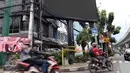 Pengendara motor melintas di depan sebuah videotron di simpang Jalan Iskandarsyah, Jakarta Selatan, Minggu (2/10). Garis polisi terpasang terkait insiden videotron yang memutar video porno pada Jumat, 30 September 2016 lalu. (Liputan6.com/Helmi Afandi)