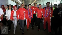 Ketua Umum PBSI, Gita Wirjawan (keempat kanan) berjalan bersama Tontowi Ahmad dan Lilyana Natsir di Bandara Soetta, Banten, Selasa (23/8/2016). Tontowi Ahmad/Lilyana Natsir berhasil meraih emas olimpiade Rio 2016. (Liputan6.com/HelmiFithriansyah)