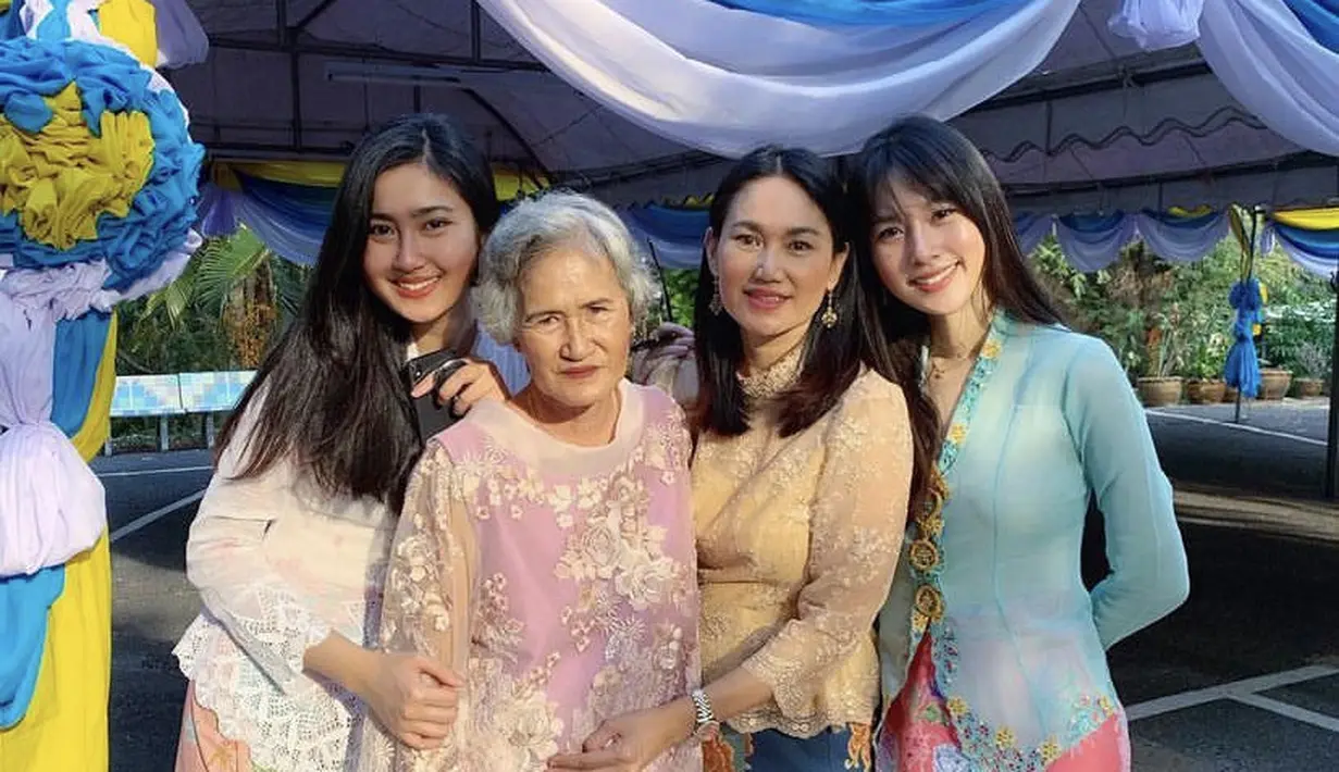Bersama keluarganya, Nong tampil mengenakan atasan biru dengan bordiran bunga dipadukan kain lilit merah motif bunga.Credit: @poydtreechada.