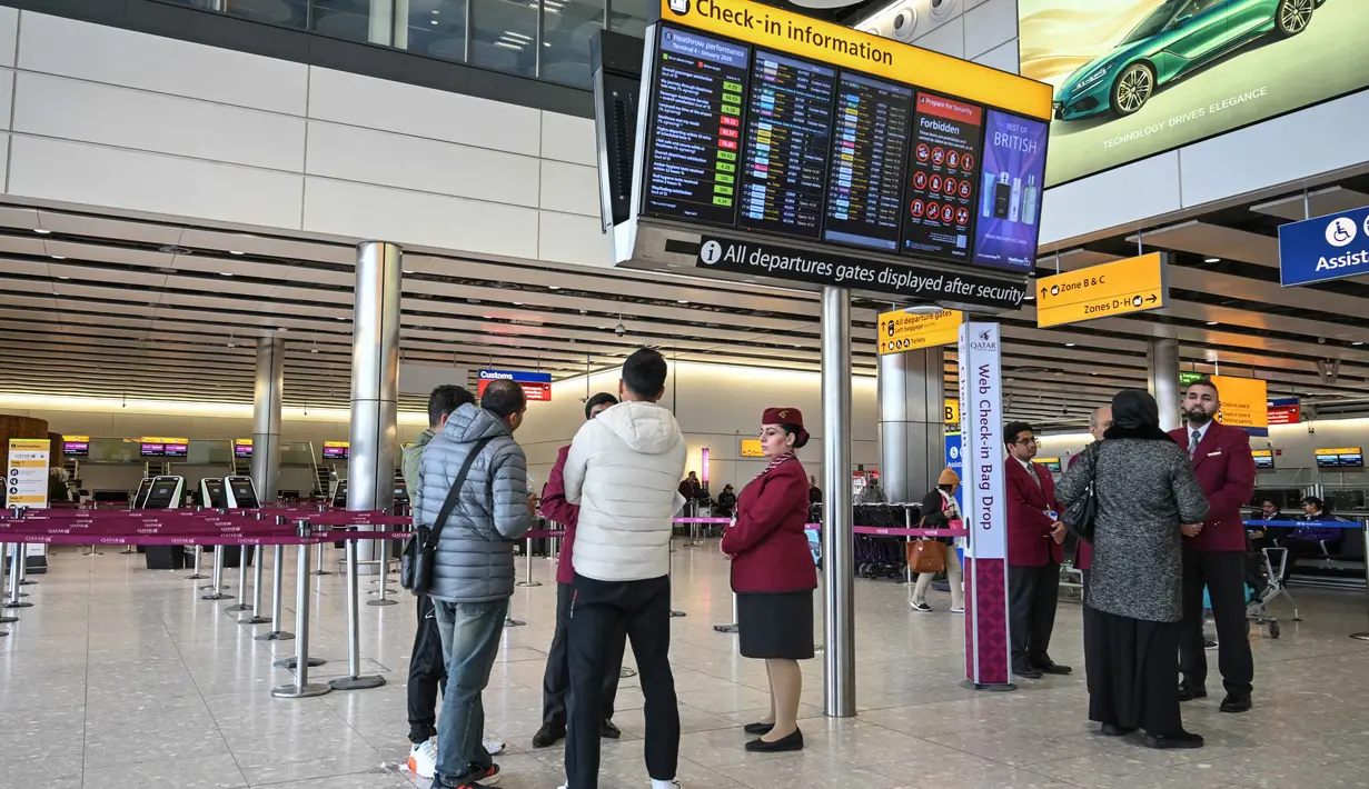 Sejumlah penerbangan jarak jauh yang biasanya singgah di Dubai kemungkinan akan dialihkan, ditunda, atau dibatalkan sepenuhnya. Tampak dalam foto, staf dari Qatar Airways membantu menjawab pertanyaan orang-orang di area check-in yang kosong di Bandara Heathrow, London pada Minggu 1 Maret 2026. (JUSTIN TALLIS/AFP)