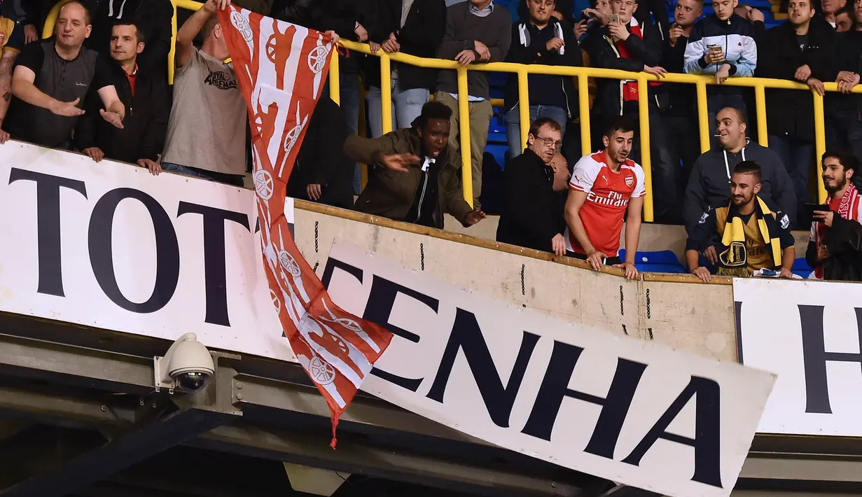 Para pendukung Arsenal merubuhkan papan bertuliskan Tottenham pada laga Piala Liga Inggris di Stadion White Hart Lane, Inggris, Rabu (23/9/2015). (AFP Photo/Ben Stansall)