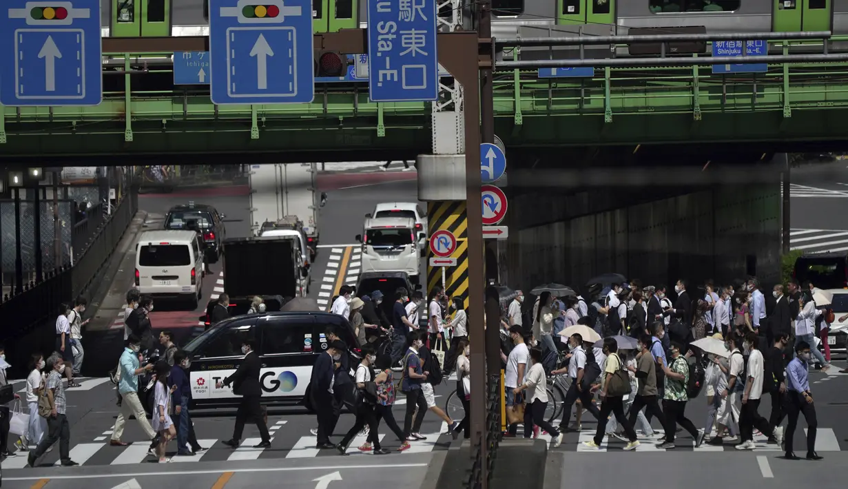 <p>Orang-orang berjalan di atas penyeberangan pejalan kaki di bawah terik matahari di Tokyo, Senin (30/5/2022). Cuaca panas pada hari Senin telah ditetapkan dengan suhu naik lebih dari 27 derajat Celcius (80,6 derajat Fahrenheit) di Tokyo, menurut Badan Meteorologi Jepang. (AP Photo/Eugene Hoshiko)</p>
