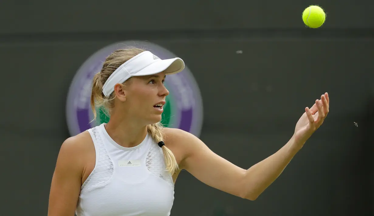 Serangga terbang ketika petenis Denmark, Caroline Wozniacki bersiap mengembalikan bola ke petenis Rusia, Ekaterina Makarova pada babak kedua Wimbledon 2018 di London, Rabu (4/7). Wozniacki tersingkir dengan skor 4-6, 6-1, 5-7. (AP/Ben Curtis)