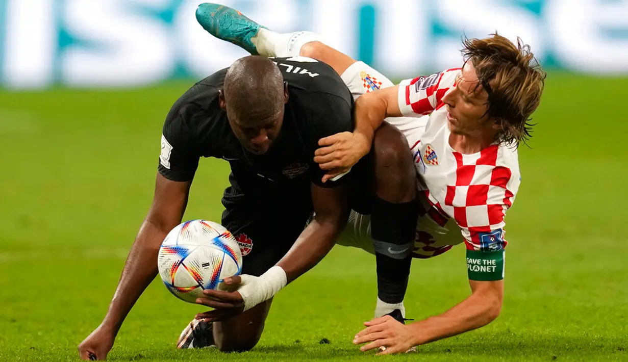 Pemain Kroasia Luka Modric berebut bola dengan pemain Kanada Kamal Miller pada pertandingan sepak bola Grup F Piala Dunia 2022 di Stadion Internasional Khalifa, Al Rayyan, Qatar, 27 November 2022. Kroasia mengalahkan Kanada dengan skor 4-1. (AP Photo/Darko Vojinovic)