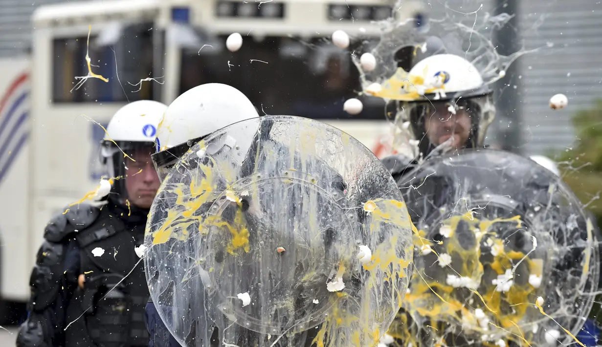 Polisi dilempari telur oleh peternak dan petani yang melakukan aksi protes saat pertemuan Menteri-menteri Eropoa di Brussels, Belgia, 7 September 2015. Aksi tersebut menuntut bantuan harga murah dan biaya yang tinggi. (REUTERS/Eric Vidal)