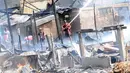 Warga mencoba memadamkan api saat kebakaran di kawasan padat penduduk Bukit Duri, Jakarta, Kamis (24/12). Kebakaran yang menghanguskan sekitar 70 petak rumah itu masih dalam penyelidikan pihak terkait. (Liputan6.com/Helmi Afandi)