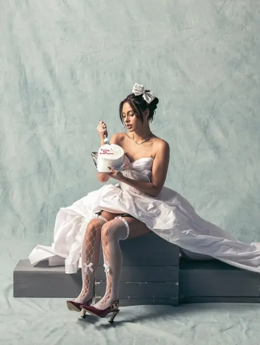 Kaos kaki panjang tersebut dipadukan dengan heels maroon. Heels model tertutup depan dan buckle emas di sisi heelsnya pun kontras dengan busana yang dikenakan. [@valerieethomas]