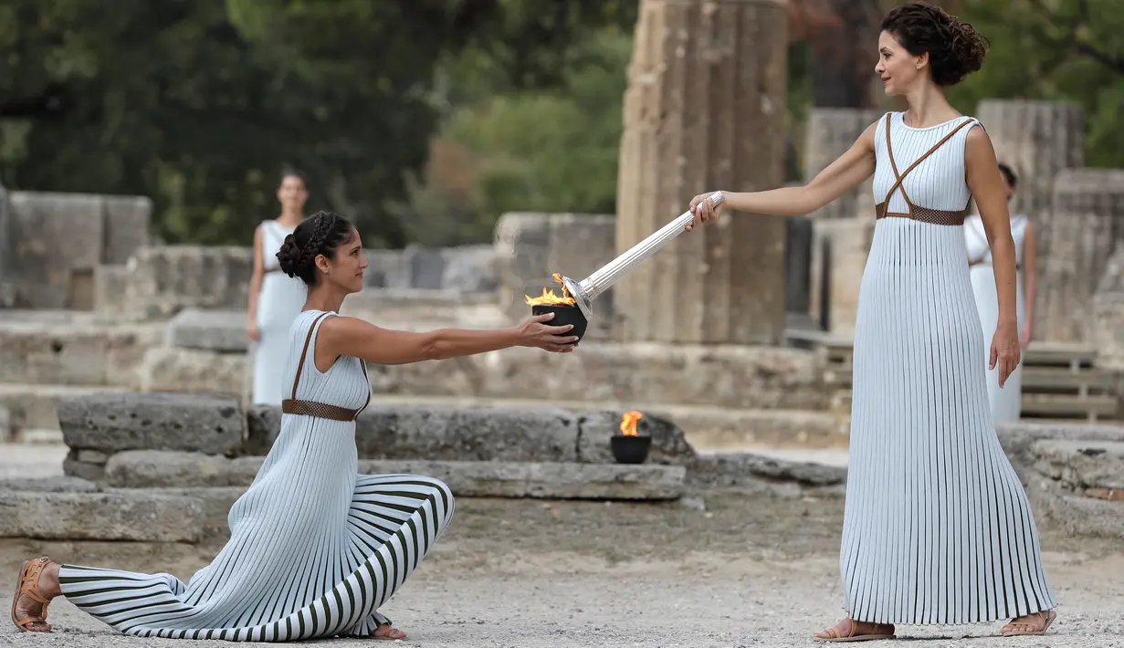 Aktris Katerina Lehou yang berperan sebagai pendeta agung (kanan) memegang obor selama gladi resik akhir penyalaan obor Olimpiade 2018 di Olympia Kuno, Yunani barat daya, Senin (23/10). (AP/Petros Giannakouris)