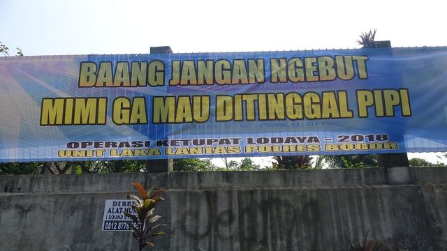 Spanduk imbauan tertib lalu lintas di kawasan Puncak, Bogor membuat pengguna jalan merasa terhibur (Liputan6.com/Achmad Sudarno)