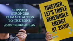 Dalam aksinya, pengunjuk rasa mendesak pemerintah Indonesia menunjukkan komitmen nyata dalam transisi energi yang adil, serta meninggalkan bahan bakar fosil. Tampak dalam foto, aktivis lingkungan menggelar aksi unjuk rasa mendesak pemerintah Indonesia untuk menunjukkan komitmen terhadap transisi dari bahan bakar fosil di depan kantor Kementerian Energi dan Sumber Daya Mineral (ESDM), Jakarta, Rabu 22 April 2026. (BAY ISMOYO/AFP)