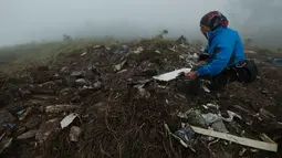 Pesawat tersebut membawa 10 orang yang terdiri dari tujuh kru dan tiga penumpang. Tampak dalam foto, seorang petugas pencarian dan penyelamatan membawa puing-puing pesawat turboprop Indonesia Air Transport berjenis ATR 42-500 di Gunung Bulusaraung, Sulawesi Selatan pada Minggu 18 Januari 2026. (Muchtamir Zaide/AFP)