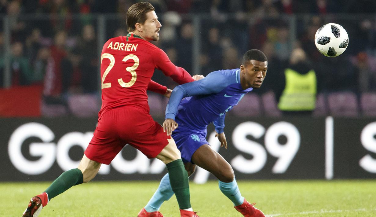 Gelandang Portugal, Adrien Silva, berebut bola dengan gelandang Belanda, Georginio Wijnaldum, pada laga persahabatan di Stade de Geneve, Swiss, Senin (26/3/2018). Portugal kalah 0-3 dari Belanda. (AP/Salvatore Di Nolfi)