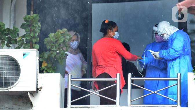 Tim paramedis dari Sudinkes Jakarta Selatan melakukan pemeriksaan kesehatan berkala kepada pasien Covid-19 yang berstatus sebagai OTG di Graha Wisata Ragunan, Senin (14/12/2020). Sebanyak 13 pasien OTG Covid-19 saat ini menjalani isolasi mandiri di Graha Wisata Ragunan. (merdeka.com/Arie Basuki)