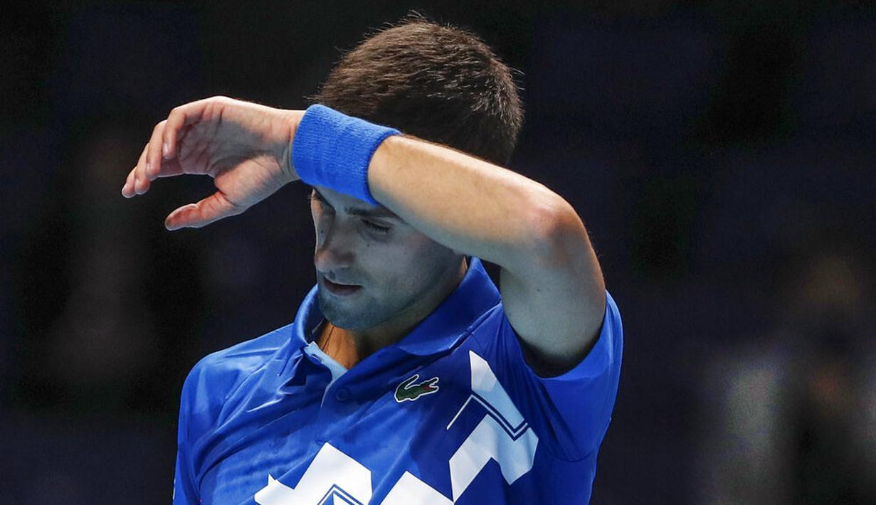Petenis Serbia, Novak Djokovic, mengusap keringat saat melawan Petenis Rusia, Daniil Medvedev, pada ATP Finals di O2 Arena, London, Kamis (19/11/2020). Petenis nomor satu dunia itu takluk 3-6 3-6. (AP/Frank Augstein)