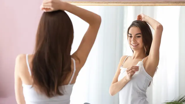 Seorang wanita menggunakan deodorant