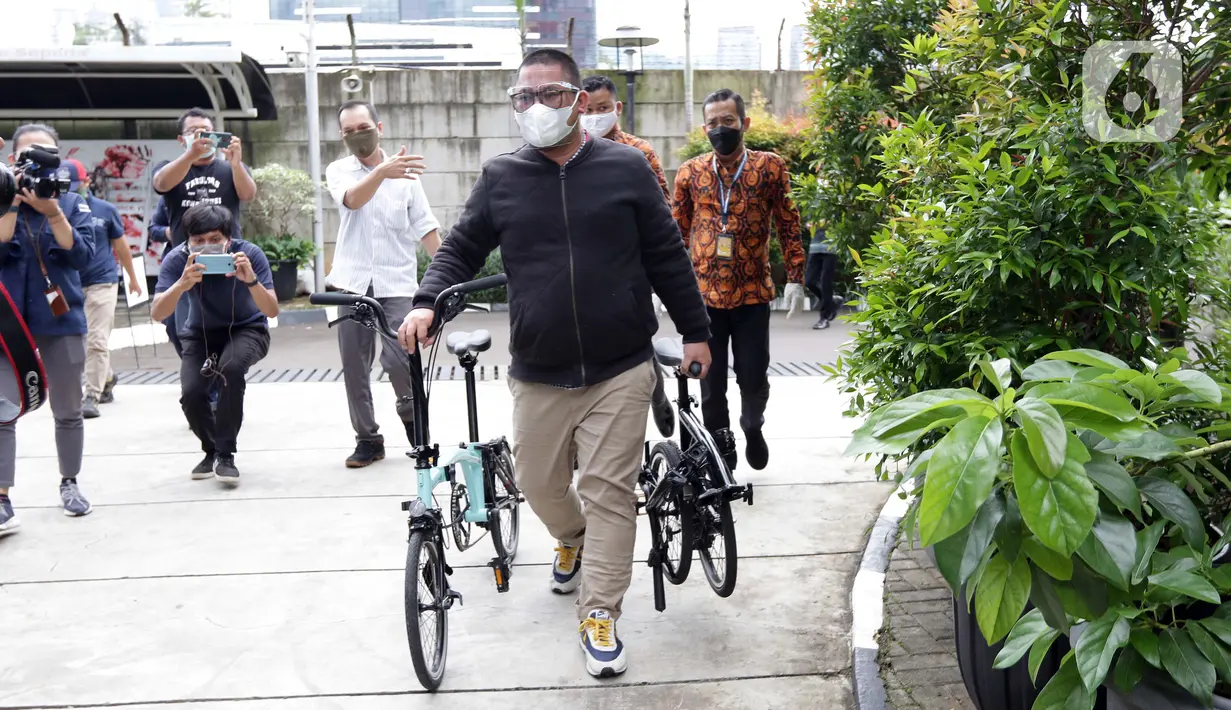 Perantara anggota Komisi II DPR Fraksi PDIP Ihsan Yunus, Agustri Yogasmara membawa sepeda merek Brompton jelang rekonstruksi di Gedung KPK, Jakarta, Rabu (10/2/2021). Agustri menyerahkan dua unit sepeda terkait kasus suap pengadaan bansos untuk Jabodetabek 2020. (Liputan6.com/Helmi Fithriansyah)
