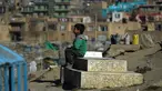 Afghan Zilgai (9), bocah penjual air ketika tengah menunggu pembeli di pemakaman Kart-e-Sakhi, Kabul, 20 Februari 2016. Anak sulung dari 8 bersaudara itu menjual air dari fajar hingga senja kepada para peziarah. (AFP PHOTO/Wakil KOHSAR)