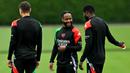 Pemain Arsenal, Raheem Sterling berbincang dengan rekan setimnya saat latihan menjelang laga lanjutan Liga Champions melawan PSG di Arsenal Training Centre, Hertfordshire, Inggris, Selasa (01/10/2024). (AFP/Glyn Kirk)