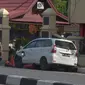 Petugas kepolisian mengamankan mobil yang digunakan terduga teroris setelah serangan di luar markas polisi di Pekanbaru, Riau (16/5). Dalam serangan tersebut satu perwira tewas dan dua lainnya terluka. (AFP Photo/Dedy Sutisna)
