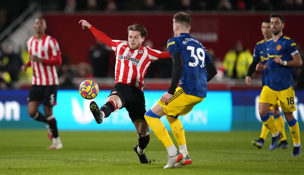 Pemain Brentford Mathias Jensen (tengah) berebut bola dengan pemain Manchester United Scott McTominay pada pertandingan sepak bola Liga Inggris di Brentford Community Stadium, London, 19 Januari 2022. Manchester United menang 3-1. (AP Photo/Matt Dunham)