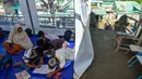 Kegiatan belajar mengajar terpaksa dilakukan di tenda-tenda darurat. Tampak dalam foto, para siswa berkumpul di kelas darurat di dalam tempat penampungan setelah sekolah mereka hancur akibat banjir bandang di daerah yang berdekatan dengan Sungai Peusangan di Bireuen, provinsi Aceh, Senin 5 Januari 2026. (CHAIDEER MAHYUDDIN/AFP)