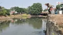 Kakek Suyitno atau Pak Dul mengambil air dari kali untuk menyiram ladang cabai di lahan bekas gusuran kawasan Pasar Ikan, Penjaringan, Jakarta, Kamis (25/7/2019). Pak Dul memanfaatkan lahan bekas gusuran dengan menanam cabai rawit untuk membantu perekonomian keluarga. (merdeka.com/Iqbal Nugroho)