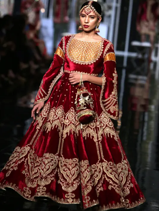 Model berjalan di runway membawakan busana rancangan MNR Design Studio selama Bridal Couture Week di Lahore, Minggu (9/12). Mereka memperagakan kreasi gaun pengantin dari sejumlah desainer ternama di Pakistan. (AP Photo/K.M. Chaudary)