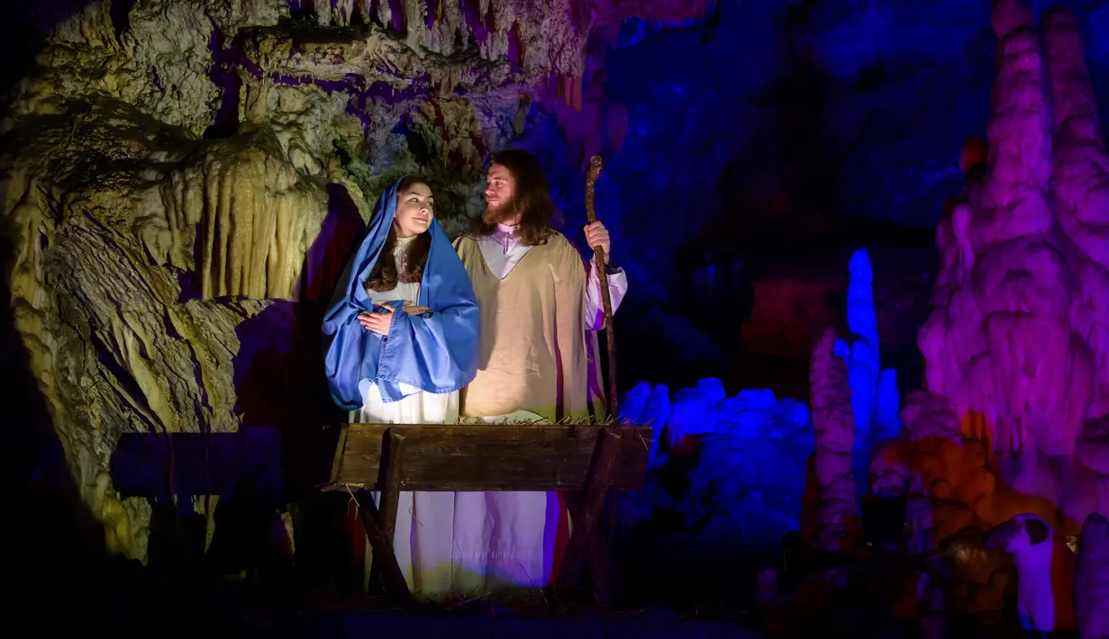 Para pemain menampilkan pertunjukan tentang kisah kelahiran bayi Yesus di Gua Postojna, Slovenia, 20 Desember 2018. Setiap perayaan Natal, Postojna Cave selalu menyajikan pertunjukkan cerita-cerita luhur Umat Kristiani di dalam gua. (Jure Makovec/AFP)