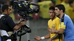 Penyerang Uruguay, Luis Suarez (kanan) saat mencoba mengontrol kemarahan rekan setimnya di Barcelona, Neymar, Stadion Arena Pernambuco, Brasil, (25/3). Pertandingan ini akhirnya berkesudahan dengan skor 2-2. (REUTERS / Paulo Whitaker)