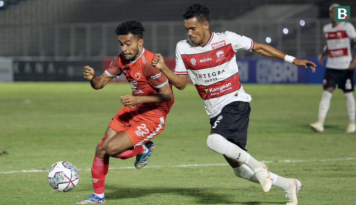 Pemain PSM Makassar, Yakob Sayuri (kiri) berusaha melewati hadangan pemain Madura United, Alfin Ismail Tuasalamony saat laga BRI Liga 1 2021/2022 antara Madura United melawan PSM Makassar di Stadion Madya, Jakarta, Minggu (12/9/2021). Pertandingan berakhir imbang 1-1. (Foto: Bola.com/Ikhwan Yanuar)