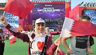Seorang penggemar sepak bola mengibarkan bendera Qatar di Hayya Fan Zone untuk menonton siaran langsung pertandingan pembukaan Piala Dunia 2022 antara Qatar dan Ekuador. (AFP/Jung Yeon-je)