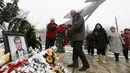 Warga meletakkan karangan bunga di dekat potret pilot asal Rusia, Oleg Peshkov di Lipetsk, Rusia, Rabu (2/12). Oleg Peshkov adalah pilot yang tewas saat pesawat tempur Su-24 yang dikemudikannya ditembak jatuh Turki pekan lalu. (REUTERS/Maxim Zmeyev)