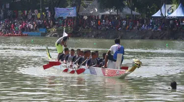 Peserta mengayuh perahu dayung naga selama Festival Danau Sunter di Jakarta, Minggau (25/2). Kegiatan tersebut untuk mengkampanyaken kebersihan dan menjaga lingkungan danau yang berada di Jakarta. (Liputan6.com/Angga Yuniar)