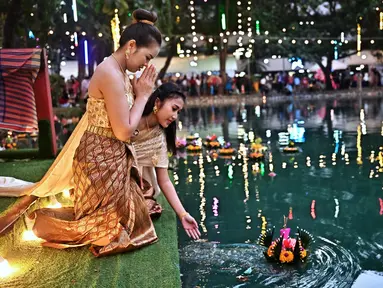 Orang-orang melepaskan lampion mengambang di kolam selama festival Loy Krathong di Bangkok (8/11/2022). Loy Krathong merupakan sebuah nama untuk festival perayaan akhir tahun yang biasa dihelat di seantero negri Thailand. (AFP/Lillian Suwanrumpha)