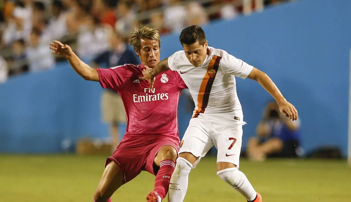Pemain belakang Real Madrid, Fabio Coentrao (kiri), berusaha merebut bola dari kaki penyerang AS Roma, Juan Iturbe, saat berlaga di Stadion Cotton Bowl, Dallas, (29/7/2014). (REUTERS/Kevin Jairaj-USA TODAY Sports)