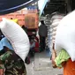 Seorang kuli angkut memanggul beras di Pasar Induk Cipinang, Jakarta, Senin (25/9). Pedagang beras Cipinang sudah menerapkan dan menyediakan beras medium dan beras premium sesuai harga eceran tertinggi (HET). (Liputan6.com/Angga Yuniar)